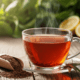 Cup of rooibos tea with dried leaves and natural herbs on a wooden table